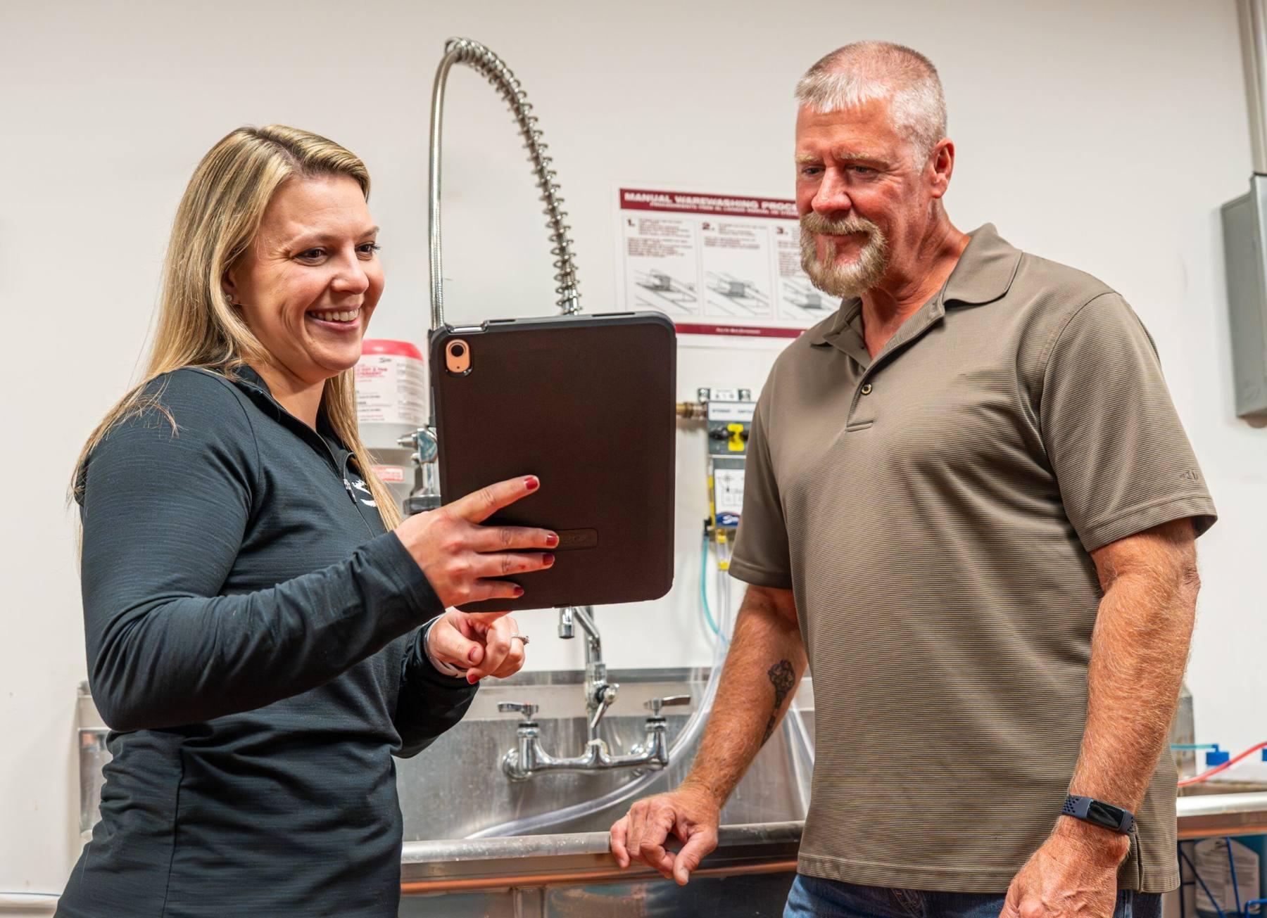 Mirza Grease Trap Services team member reviewing completed service with a client